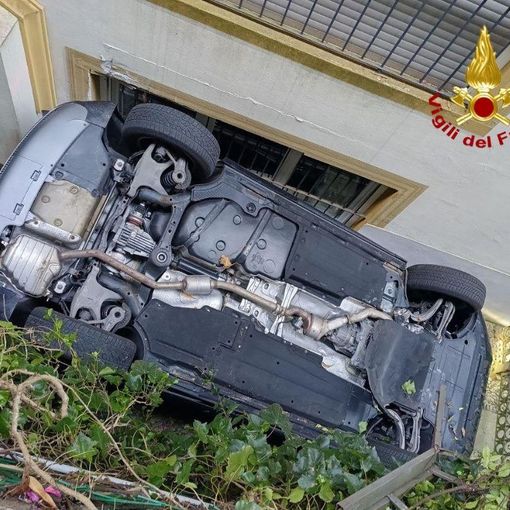 Auto cade da una piazzola ribaltandosi e incastrandosi contro il muro di una casa