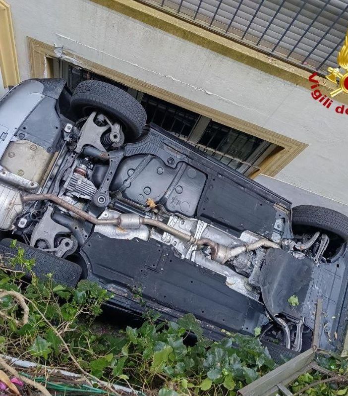 Auto cade da una piazzola ribaltandosi e incastrandosi contro il muro di una casa
